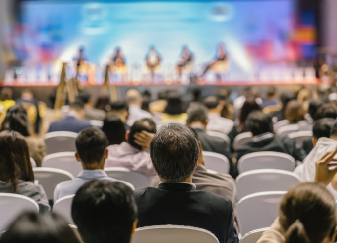 Rear view of Audience listening Speakers on the stage in the con