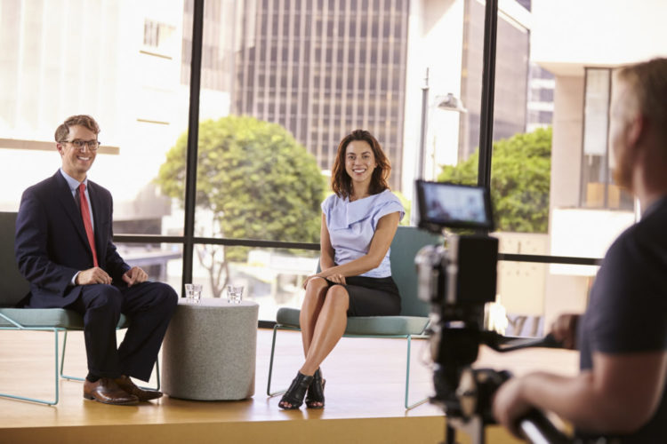 Smartly dressed man and woman on set for a TV interview